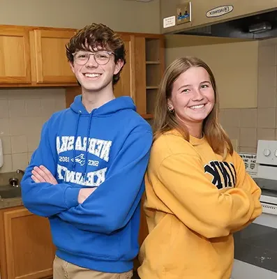 two students stand back to back